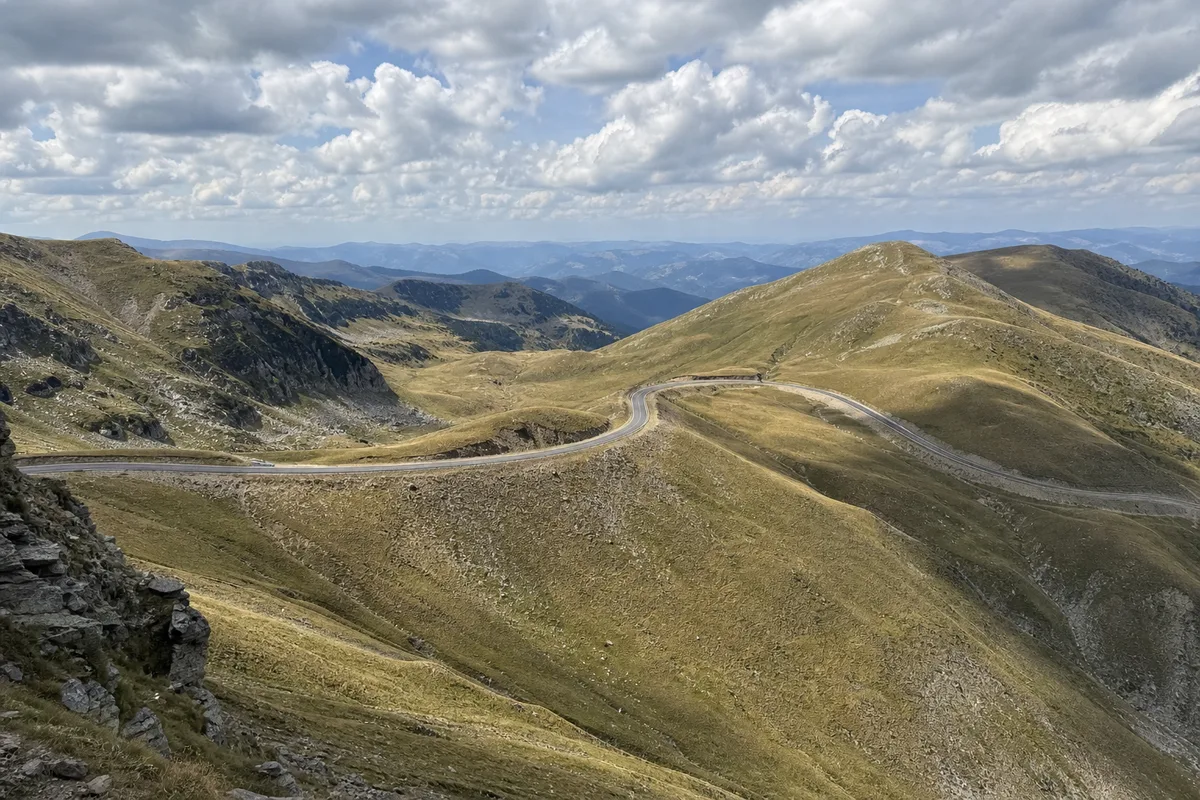 Pasul Urdele pe Transalpina, drumul trecând peste șaua dintre vârfuri, panoramă largă