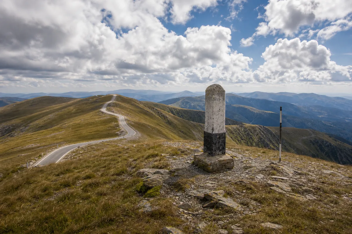 Pasul de mare altitudine de pe Transalpina, drumul trecând peste șaua dintre culmi rotunjite