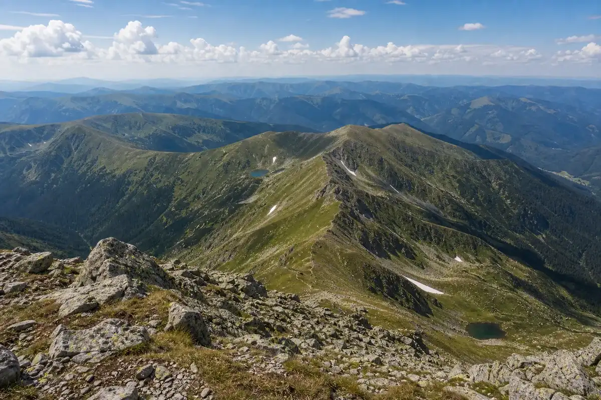 Panoramă amplă de pe Vârful Parângul Mare peste creste nesfârșite din Carpații Meridionali